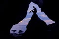 Photographer in front of the cave near the sea. Royalty Free Stock Photo