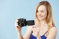 Blonde woman with camera on blue