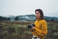 Photographer girl take photo on camera on background autumn froggy mountain, tourist enjoy nature mist landscape, hobby concept