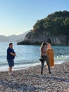 Budva, Montenegro - 01.08.22: Photographer girl takes photo of a woman and a man near a rock Royalty Free Stock Photo