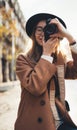 Photographer in glasses with retro camera. Tourist portrait. Girl in hat travels in Barcelona holiday. Sunlight flare street Royalty Free Stock Photo