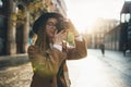 Photographer in glasses with retro photo camera. Tourist portrait. Girl in hat travels in Barcelona holiday. Sunlight flare street Royalty Free Stock Photo