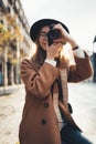 Photographer in glasses take photo on retro camera. Tourist portrait. Girl in hat travels in Barcelona holiday. Sunlight flare Royalty Free Stock Photo