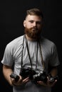 Photographer in grey t-shirt with a bunch of different vintage old film cameras looks into the camera. Close up portrait Royalty Free Stock Photo