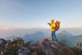 Photographer hand holding camera and standing on top of the mountain in nature. Travel concept. Vintage tone Royalty Free Stock Photo