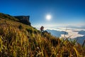 Photographer hand holding camera and standing on top of the rock in nature. Phu chi fa mountains in Chiang rai, Thailand Royalty Free Stock Photo