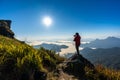 Photographer hand holding camera and standing on top of the rock in nature. Travel concept. Royalty Free Stock Photo