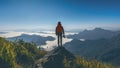 Photographer hand holding camera and standing on top of the rock in nature. Travel concept. Vintage tone.