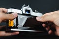 Photographer hand loading 35mm film into SLR film camera Royalty Free Stock Photo