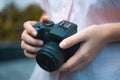 Photographer hands holding a digital camera, focusing and taking photos, macro closeup
