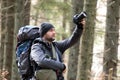 Photographer with hiking backpack taking pictures of nature with digital photo camera Royalty Free Stock Photo