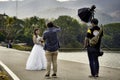 Photographer and his assistand making portrait photo for bride holding flowers