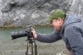 A photographer with his camera on a stand in detail to take photo of Rhine whitewater in Rhine Gorge Ruinaulta, Switzerland.