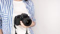 Photographer holding dslr camera. Self portrait, front view. Faceless nice woman with brown red hair in a tshirt with hands Royalty Free Stock Photo