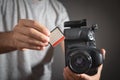 Photographer holding memory card insert DSLR camera Royalty Free Stock Photo
