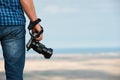 Photographer holding a photo digital camera in his hands Royalty Free Stock Photo