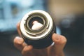 Photographer is holding a photography lens in his hand, laptop in the blurry background Royalty Free Stock Photo