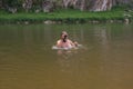 photographer holding waterproof camera and swimming in river, trying to catch some interesting shots Royalty Free Stock Photo