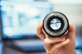 Photographer is holding a photography lens in his hand, laptop in the blurry background Royalty Free Stock Photo