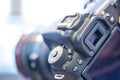 Photographer holds a reflex camera with telephoto lens in his hand. Table and laptop in the blurry background Royalty Free Stock Photo