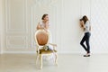 Photographer taking pictures the young bride in the studio near the chair Royalty Free Stock Photo