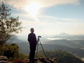 Photographer looks into the landscape and listen the silence. Man prepare camera to takes photos Royalty Free Stock Photo