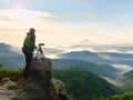 Photographer looks into the landscape and listen the silence. Man prepare camera to takes photos Royalty Free Stock Photo