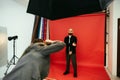 Photographer makes a photo shoot for a handsome bearded man on a red background in a photo studio Royalty Free Stock Photo