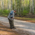 Photographer making photo with old film camera in morning birch forest Royalty Free Stock Photo