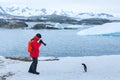 Photographer and model, bird wildlife nature photography, tourist taking photo of penguin in Antarctica