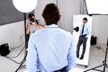 Photographer, model shoot and camera in studio, behind the scenes and equipment on set for advertising. Man, back and Royalty Free Stock Photo