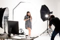 Photographer and pretty model working in modern lighting studio Royalty Free Stock Photo