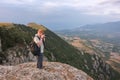 Photographer in mountains takes photos using reflex camera in Crimea Royalty Free Stock Photo