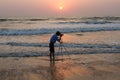 The photographer photographs from a tripod standing in the sea. India, Karnataka, Gokarna, February 2017