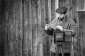 Photographer prepares for shooting and inserts film holder into retro large format camera. Concept - photography of the 1930s-