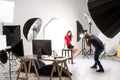 Photographer and pretty model working in modern lighting studio
