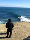 A photographer on the rock in santa cruz waiting for some cool s