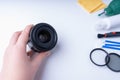 Photographer`s hand holding a camera lens, accessories for cleaning the camera on a white background Royalty Free Stock Photo