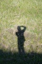 The photographer`s shadow on the summer grassy ground . Royalty Free Stock Photo