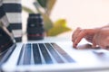 Photographer`s workplace, laptop and camera lenses on a white table, hands on keyboard close up Royalty Free Stock Photo