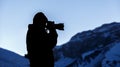 Photographer shooting snow-capped mountains