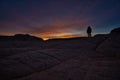 Photographer silhouette as sun rises over White Pocket AZ