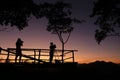 Photographer silhouette on the mountain taking photo shooting landscape with sunset or sunrise - photographer woman with camera Royalty Free Stock Photo