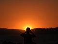 Photographer Silhouette.. Sunset, man takes photographs in the sun, golden and dark colors draw his silhouette Royalty Free Stock Photo