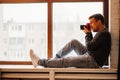 photographer sits on windowsills and takes pictures. training in photography.