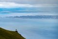 A photographer stand on a rock