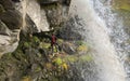 The photographer stands under the waterfall and takes a photo of the nature of Kamchatka