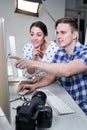 Photographer In Studio Reviewing Images From Photo Shoot On Computer With Female Client