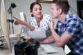 Photographer In Studio Reviewing Images From Photo Shoot On Computer With Female Client