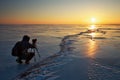 Photographer take pictures on the ice at sunset Royalty Free Stock Photo